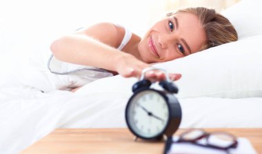 Evdeki yatak odasında uyuyan genç kadın ve çalar saat.