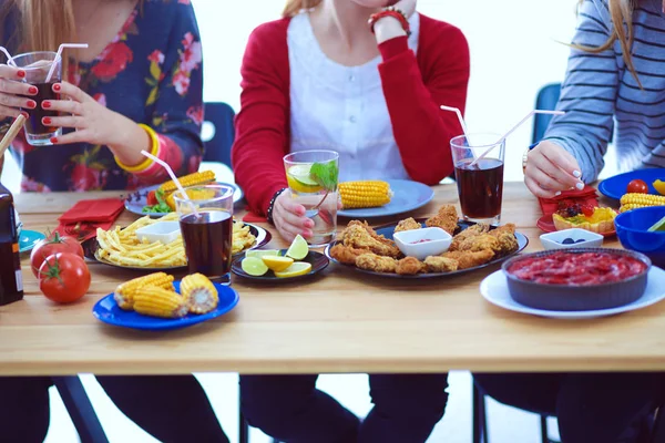 Vue du dessus du groupe de personnes qui dînent ensemble tout en étant assis à une table en bois. De la nourriture sur la table. Les gens mangent fast food. — Photo