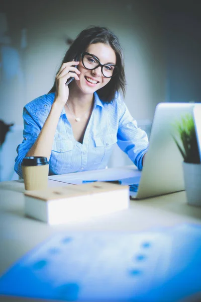 Belle jeune femme d'affaires assise au bureau et parlant sur un téléphone portable. Femme d'affaires — Photo