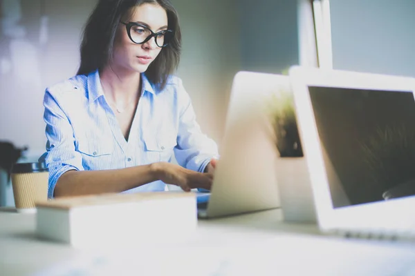 Młoda kobieta siedząca przy biurku, patrząca na ekran laptopa. Młoda kobieta — Zdjęcie stockowe