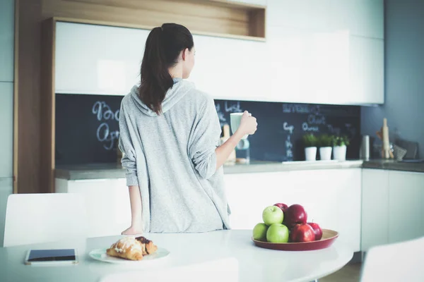 Glückliche Frau trinkt Tee in der Küche zu Hause. — Stockfoto