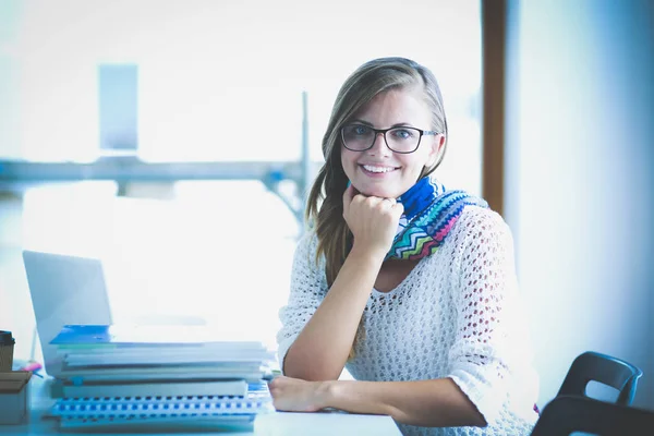 Młoda kobieta siedząca za biurkiem wśród książek. Student — Zdjęcie stockowe