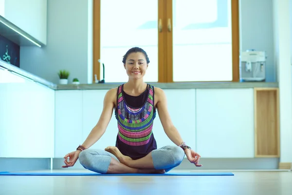 Mujer joven haciendo yoga en casa en la posición de loto. Yoga. Una mujer. Estilo de vida — Foto de Stock
