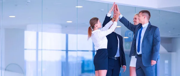 Equipo de negocios uniendo sus manos de pie en la oficina — Foto de Stock