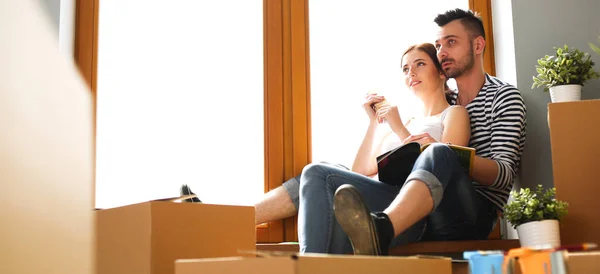 Par som flyttar i huset sitter på fönsterbrädan — Stockfoto