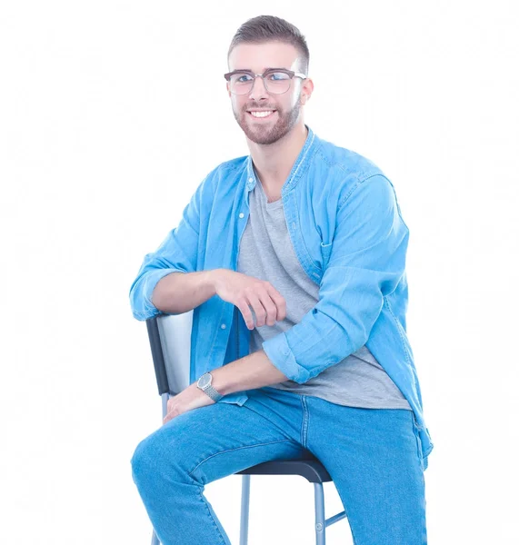 Jeune homme assis sur la chaise isolé sur fond blanc — Photo