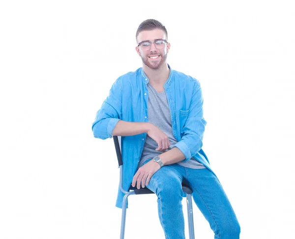 Young man sitting on the chair isolated over white background — Stock Photo, Image