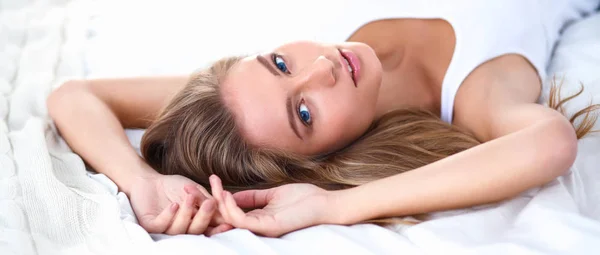 Pretty woman lying down on her bed at home