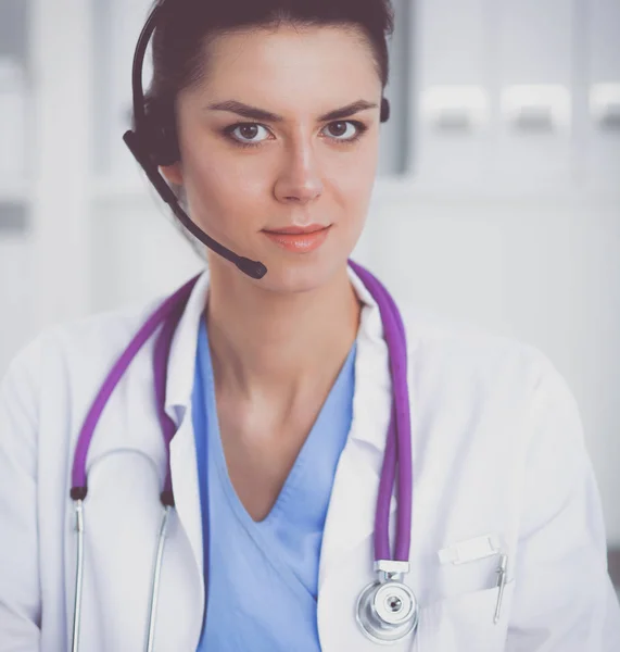 Dokter draagt een headset zittend achter een bureau met laptop — Stockfoto
