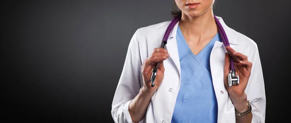 Mujer doctora joven con estetoscopio aislado en gris — Foto de Stock