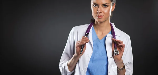 Jeune médecin femme avec stéthoscope isolé sur gris — Photo