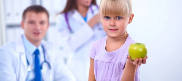 Barn och medicin koncept - kvinnlig läkare ger ett äpple till liten flicka — Stockfoto