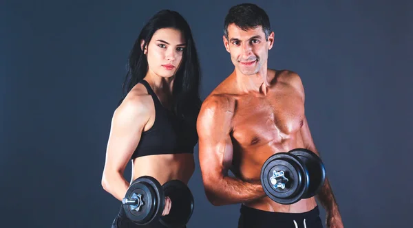 Hombre y mujer atléticos con mancuernas — Foto de Stock