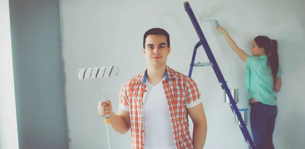 Portret van gelukkig lachend jong koppel schilderij interieur wand nieuw huis — Stockfoto