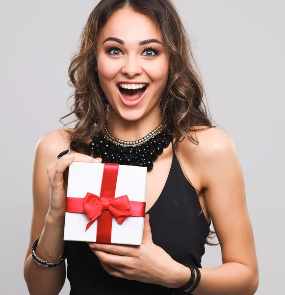 Mujer joven sonrisa feliz celebrar caja de regalo en las manos, aislado sobre fondo gris —  Fotos de Stock