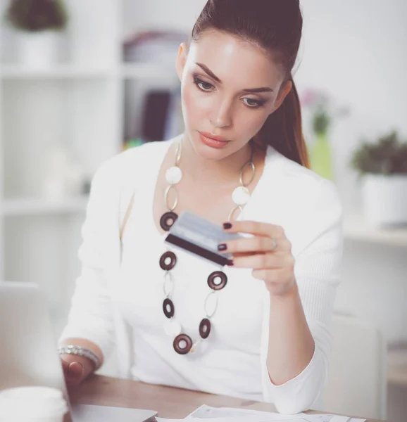 Mujer de negocios haciendo compras en línea a través de ordenador portátil y tarjeta de crédito en la oficina —  Fotos de Stock