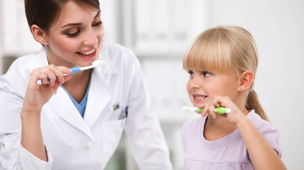 Tandlæge og lille pige i tandlægen kontor. - Stock-foto