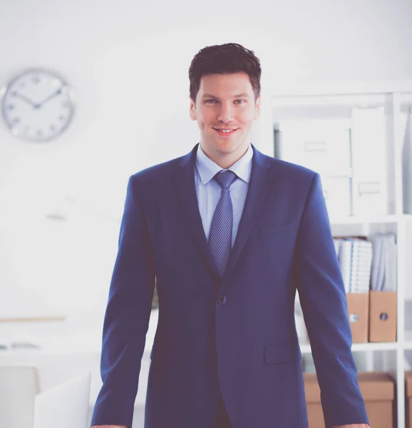 Vertrouwen succesvolle jonge zakenman leunend wapens op zijn Bureau — Stockfoto