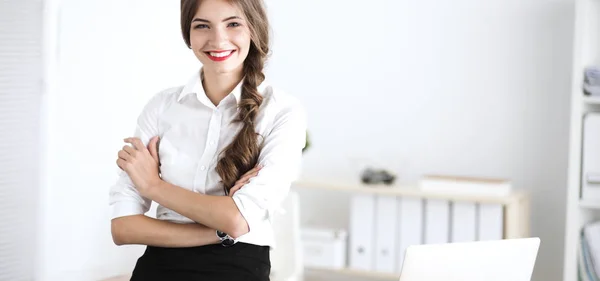 Attraente donna d'affari con le braccia incrociate in piedi in ufficio — Foto Stock