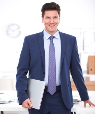 Ofiste masasının karşısında duran bir iş adamı ya da yönetici.