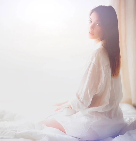 Portret van mooie vrouw op bed op de slaapkamer — Stockfoto