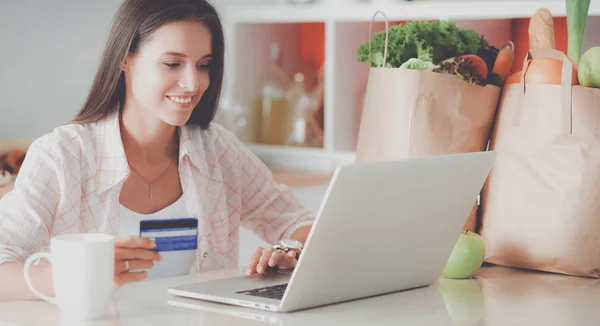 Smiling woman online shopping using tablet and credit card in kitchen — Stock Photo, Image