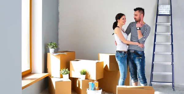 Heureux jeune couple déballer ou emballer des boîtes et emménager dans une nouvelle maison — Photo