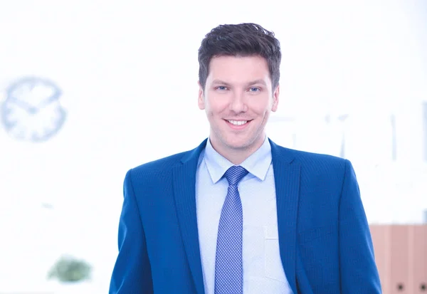 Business man or manager standing against his desk at office with  arms folded — Stock Photo, Image