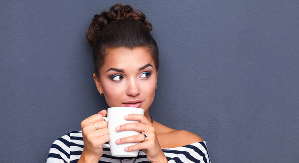 Portrait of young woman with cup tea or coffee