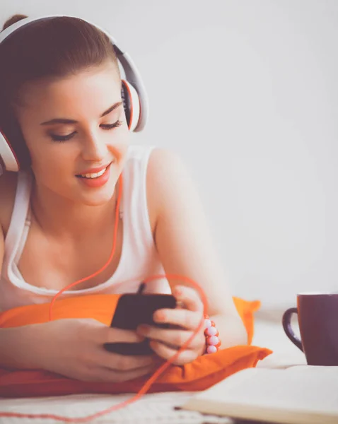 Mujer joven tumbada en el suelo y escuchando música — Foto de Stock