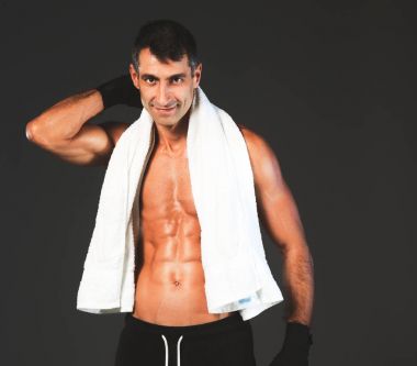 Siyah arka plan üzerine ayakta güçlü atletik adam