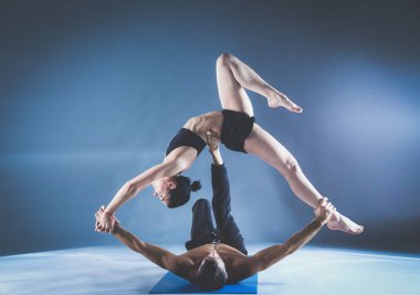 Genç çift Acro yoga mat Studio birlikte uygulamak. Acroyoga. Çift yoga. Ortak yoga.