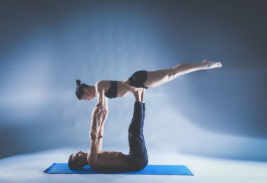 Genç çift Acro yoga mat Studio birlikte uygulamak. Acroyoga. Çift yoga. Ortak yoga.