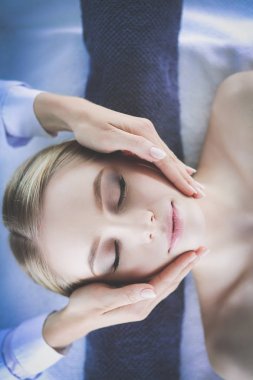 Masaj masasında uzanmış gözleri kapalı rahatlayan genç bir kadın. - Kadın. Spa salonu