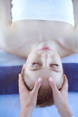 Masaj masasında uzanmış gözleri kapalı rahatlayan genç bir kadın. - Kadın. Spa salonu