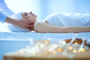 Masaj masasında uzanmış gözleri kapalı rahatlayan genç bir kadın. - Kadın. Spa salonu