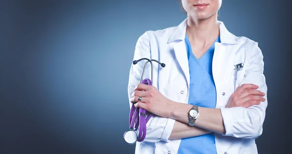 Portrait of young female doctor holding a stethoscope, isolated on black background — Stock Photo, Image