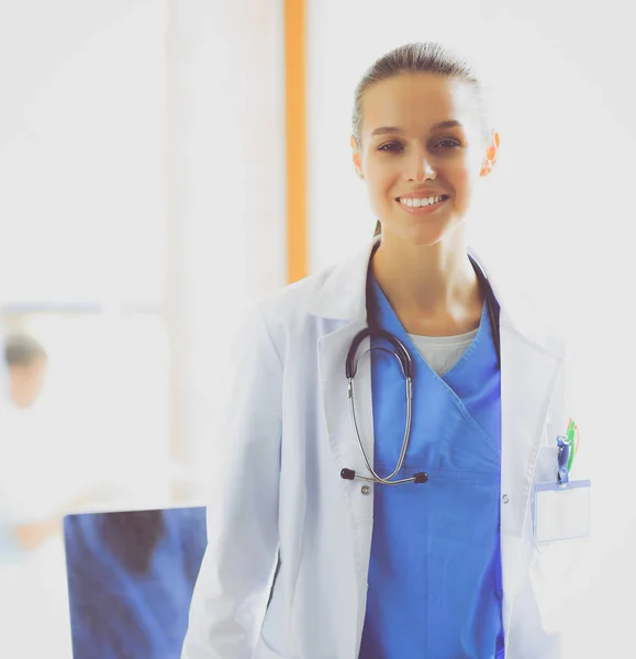 Woman doctor standing at hospital near desk — Stock Photo, Image