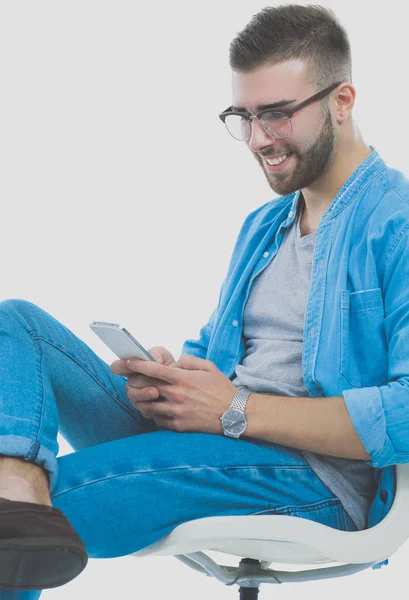 Junger Mann auf Stuhl sitzend und mit Handy. Startupper. Jungunternehmer. — Stockfoto