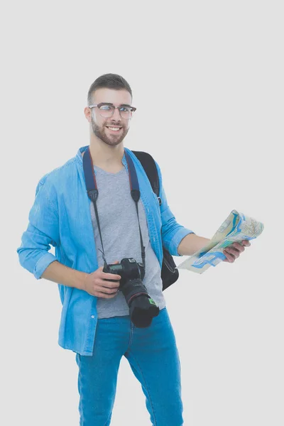 Junger Mann, der eine Landkarte auf weißem Hintergrund hält. junger Mann mit einer Landkarte auf weißem Hintergrund. ein Tourist im Urlaub. Suche nach Sehenswürdigkeiten. Abenteuerlustige. — Stockfoto
