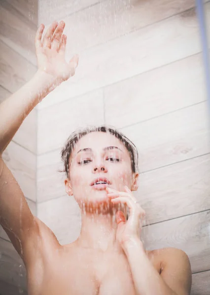 Молода жінка під душем у ванній . — стокове фото