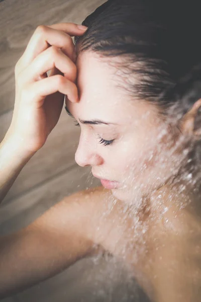 Junge schöne Frau unter der Dusche im Badezimmer. — Stockfoto