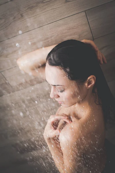 Jeune femme belle sous la douche dans la salle de bain . — Photo