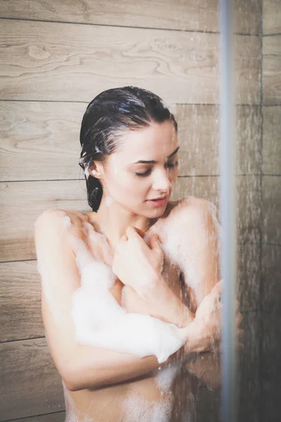 Junge schöne Frau unter der Dusche im Badezimmer. — Stockfoto