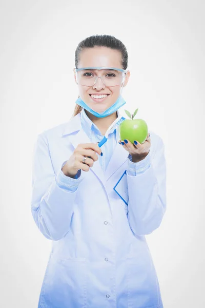 Tandläkare läkare kvinna hålla grönt färskt äpple i handen och tandborste. Tandläkare. Kvinnliga läkare — Stockfoto