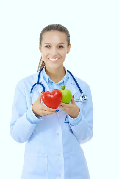 Bella sorridente medico femminile con cuore rosso e mela verde. Donna medico — Foto Stock