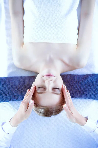 Jovem deitada em uma mesa de massagem, relaxando com os olhos fechados. Mulher. Salão de Spa — Fotografia de Stock