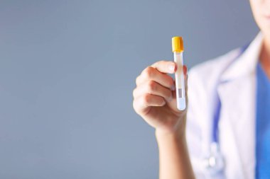 Laboratuvarda ya da laboratuvarda test tüpüne bakarak kadın tıbbi ya da araştırma uzmanı ya da doktor