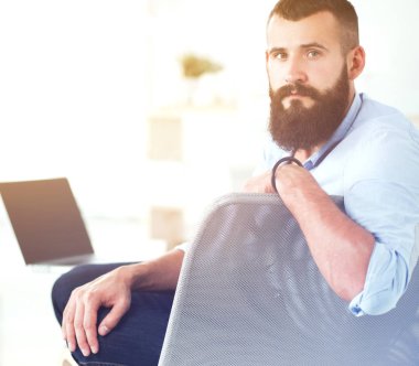 Genç işadamı koltukta oturuyor.