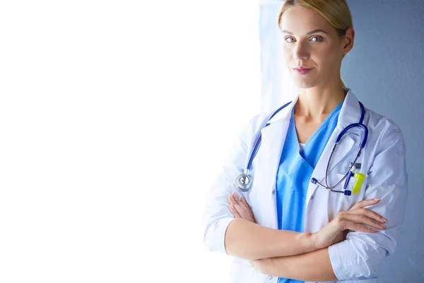 Portrait of young woman doctor with white coat standing in hospital — Stock Photo, Image